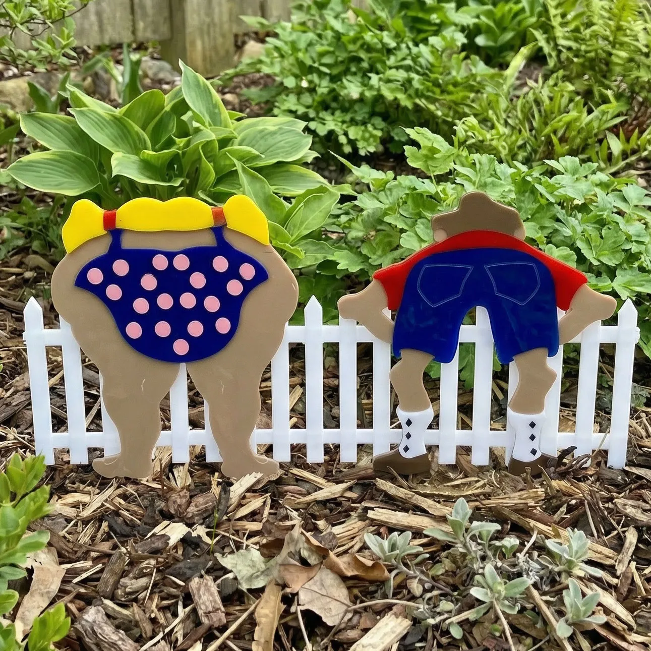 Colorful garden decor behind white fence